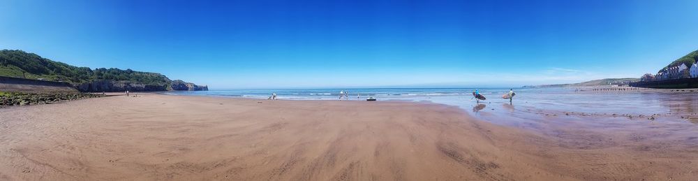 Scenic view of beach against clear blue sky