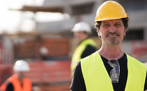 Portrait of engineer wearing hardhat at construction site