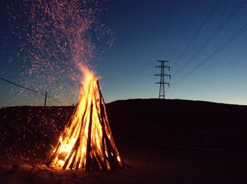 Fire on field against sky at night