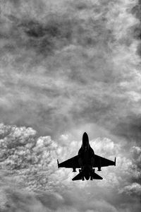 Low angle view of silhouette airplane against sky