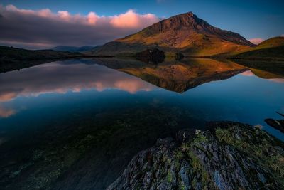 Scenic view of lake by mountains against sky