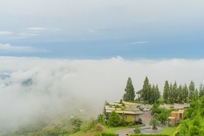 Scenic view of trees and building against sky