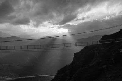 Bridge over mountain against sky during sunset