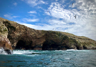 Rock formations by sea against sky