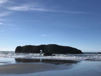 Rock formation on beach against sky