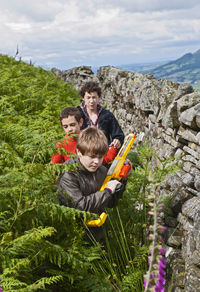 Three teenage boys playing outside with their toy guns