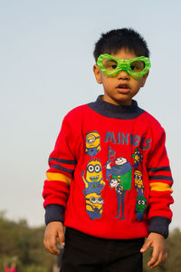 Portrait of boy wearing novelty glasses against sky