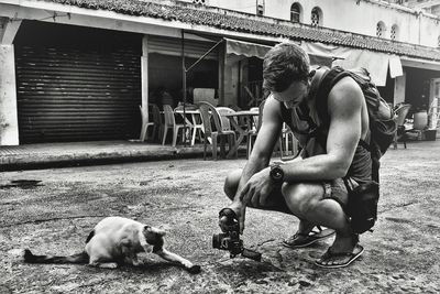 Side view of young man photographing outdoors