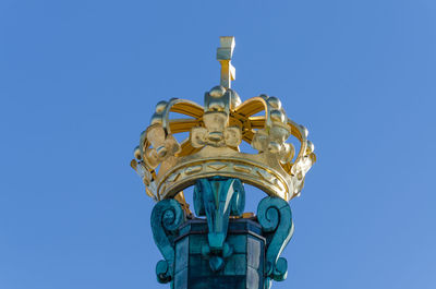 Low angle view of skansken kronan golden crown against clear blue sky, gothenburg, sweden