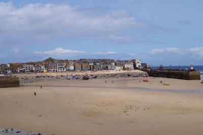 Beach by buildings against sky in city