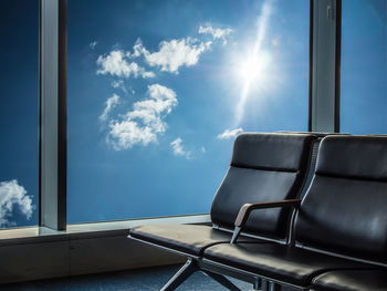 Chair against blue sky seen through window