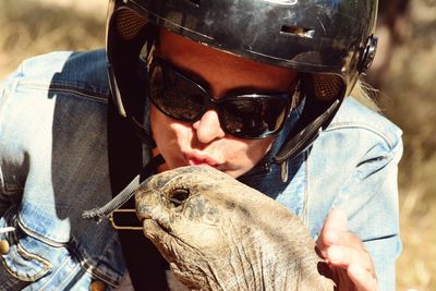 Close-up of young woman kissing tortoise