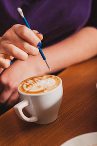 Close-up of hand holding coffee cup