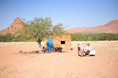 Cart in desert against clear sky