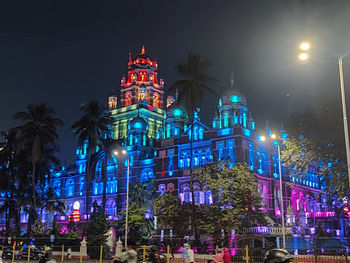 Low angle view of illuminated buildings against sky at night