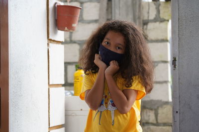 Portrait of woman standing against wall