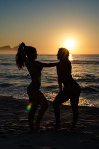 Woman standing on beach during sunset