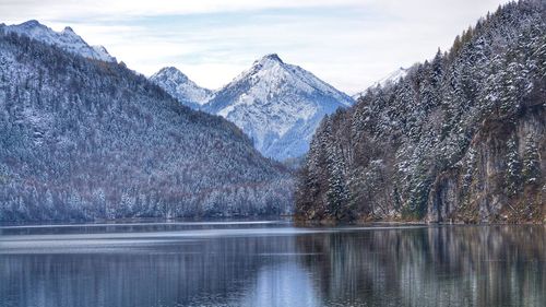 Scenic view of frozen lake by mountains against sky