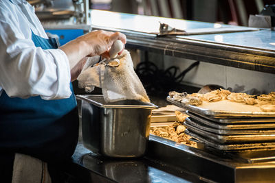 Midsection of man preparing food in kitchen