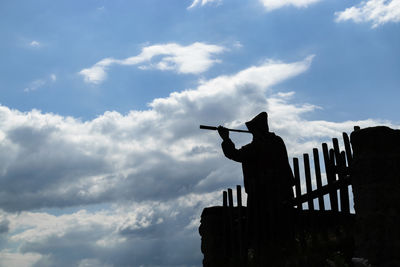 Low angle view of silhouette man standing against sky