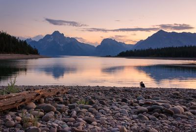 Scenic view of lake against mountains during sunset