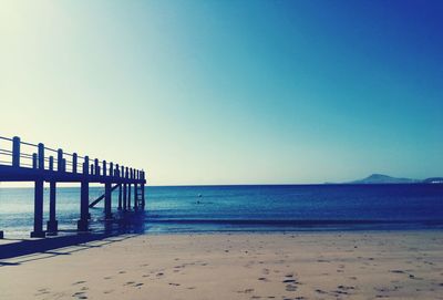 Pier over sea against clear sky