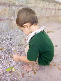 High angle view of boy looking away against wall