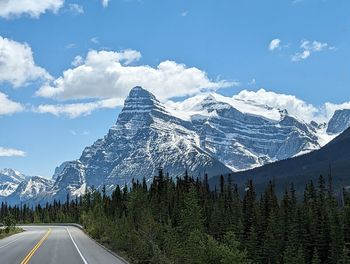 Road amidst snowcapped mountains against sky