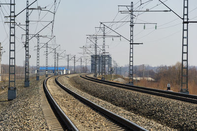 Railroad tracks amidst electricity pylons