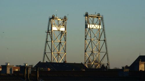 Cranes against clear sky