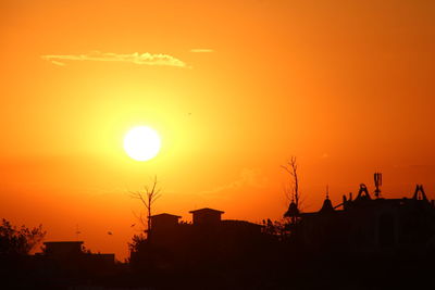 Silhouette buildings against sky during sunset