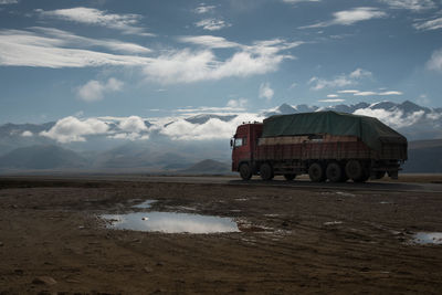 Truck on desert road cloudy sky