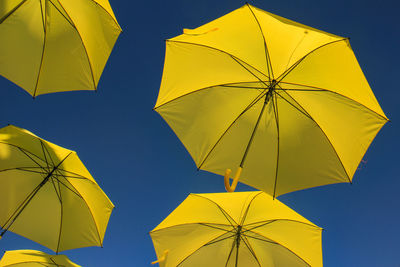 Low angle view of yellow umbrella against sky