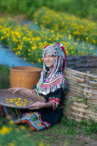 Woman wearing hat while sitting on field