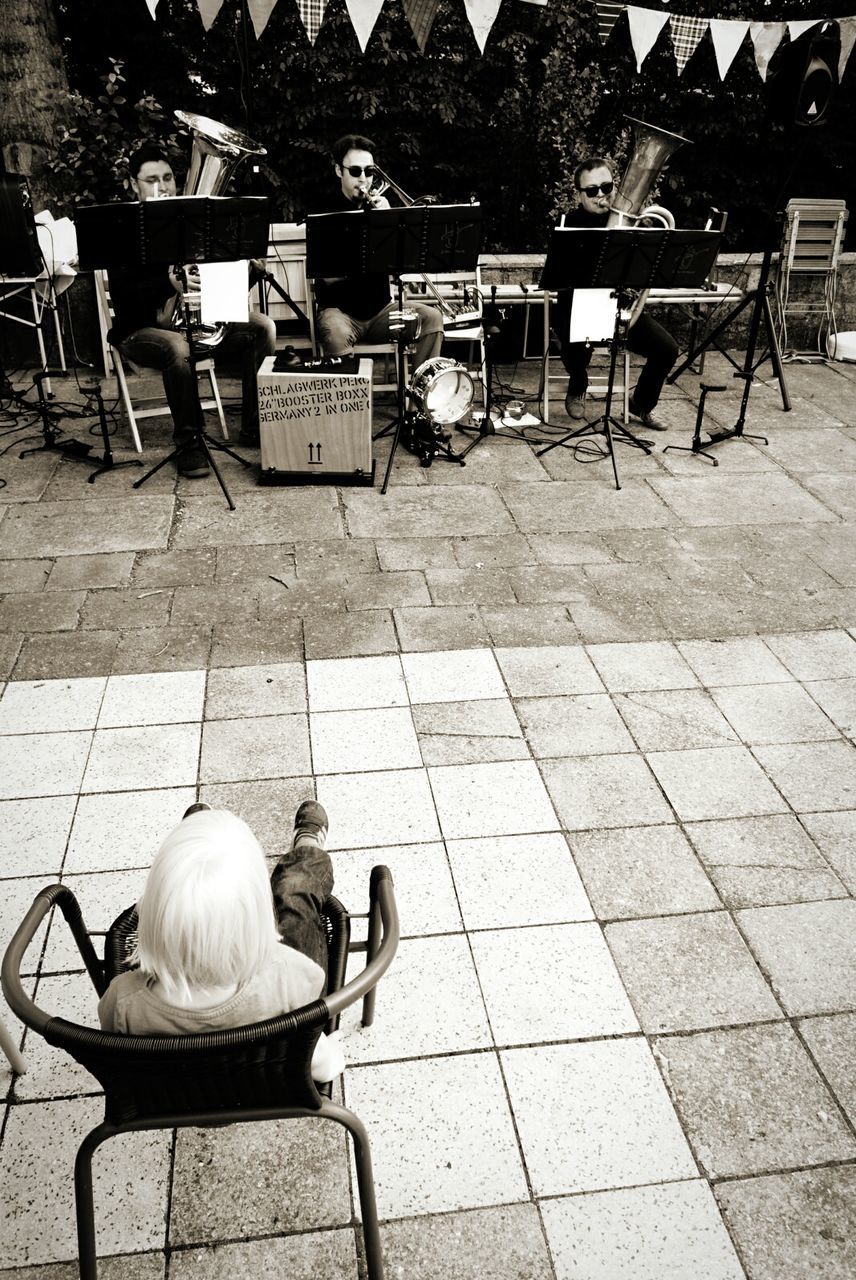 chair, sitting, relaxation, seat, lifestyles, empty, sidewalk cafe, table, leisure activity, men, bench, cobblestone, casual clothing, absence, rear view, person, high angle view