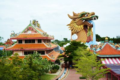 Statue of temple against building and sky