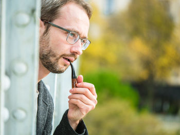 Mid adult man looking away while smoking outdoors