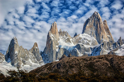 Scenic view of snowcapped mountains against cloudy sky