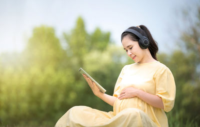 Side view of young woman using mobile phone