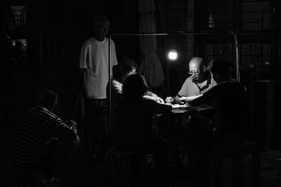 Rear view of people sitting on table