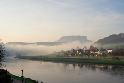 Scenic view of lake against sky with fog 