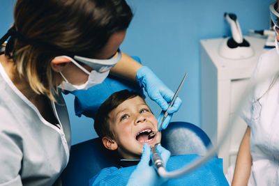 Dentists examining boy in clinic