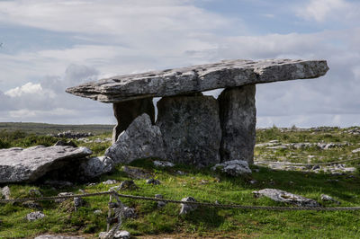 View of rocks on field against sky