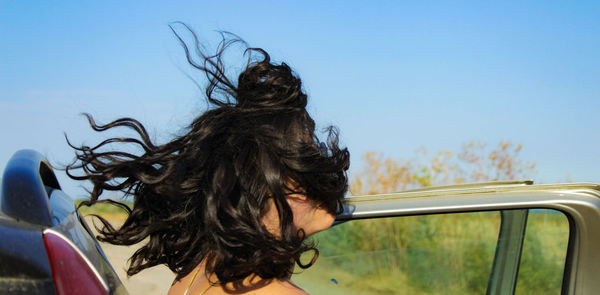 Close-up of young woman against clear sky