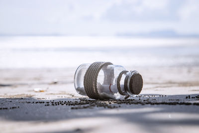 Close-up of water bottle on beach