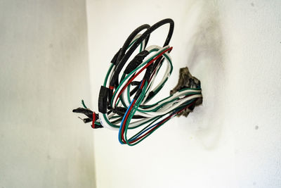 Close-up of electric cables in white wall