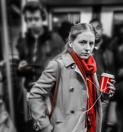 Portrait of young woman holding red while standing outdoors