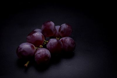 Close-up of grapes over black background