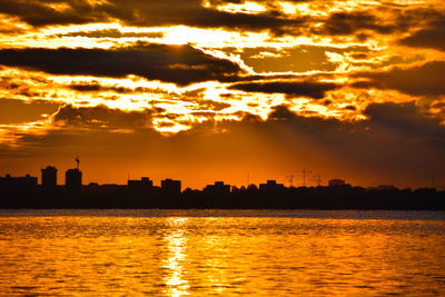 Scenic view of silhouette buildings against sky during sunset