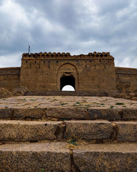 Historic ruin building against cloudy sky